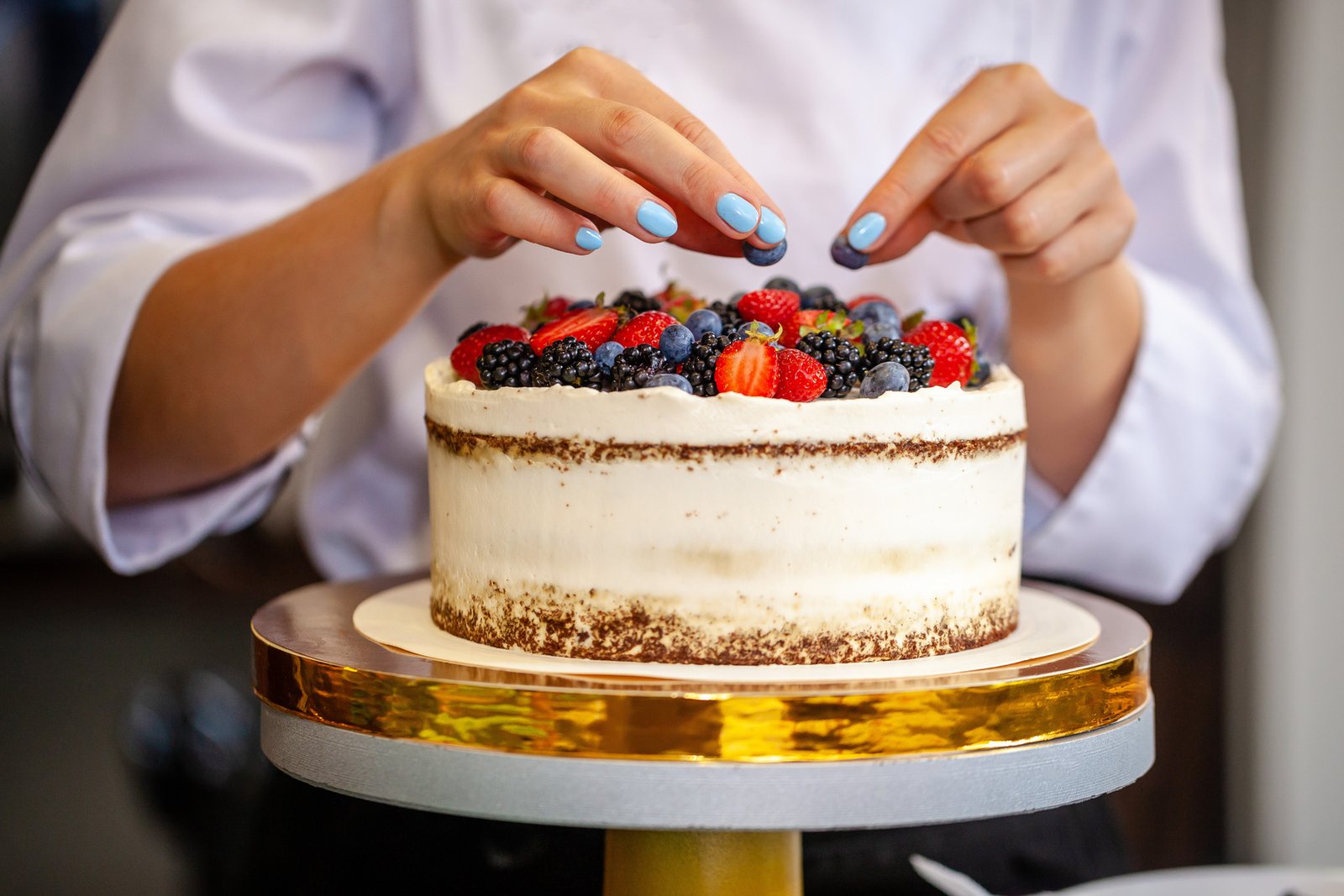 Finishing a fresh cream cake at Top Hat Bakery